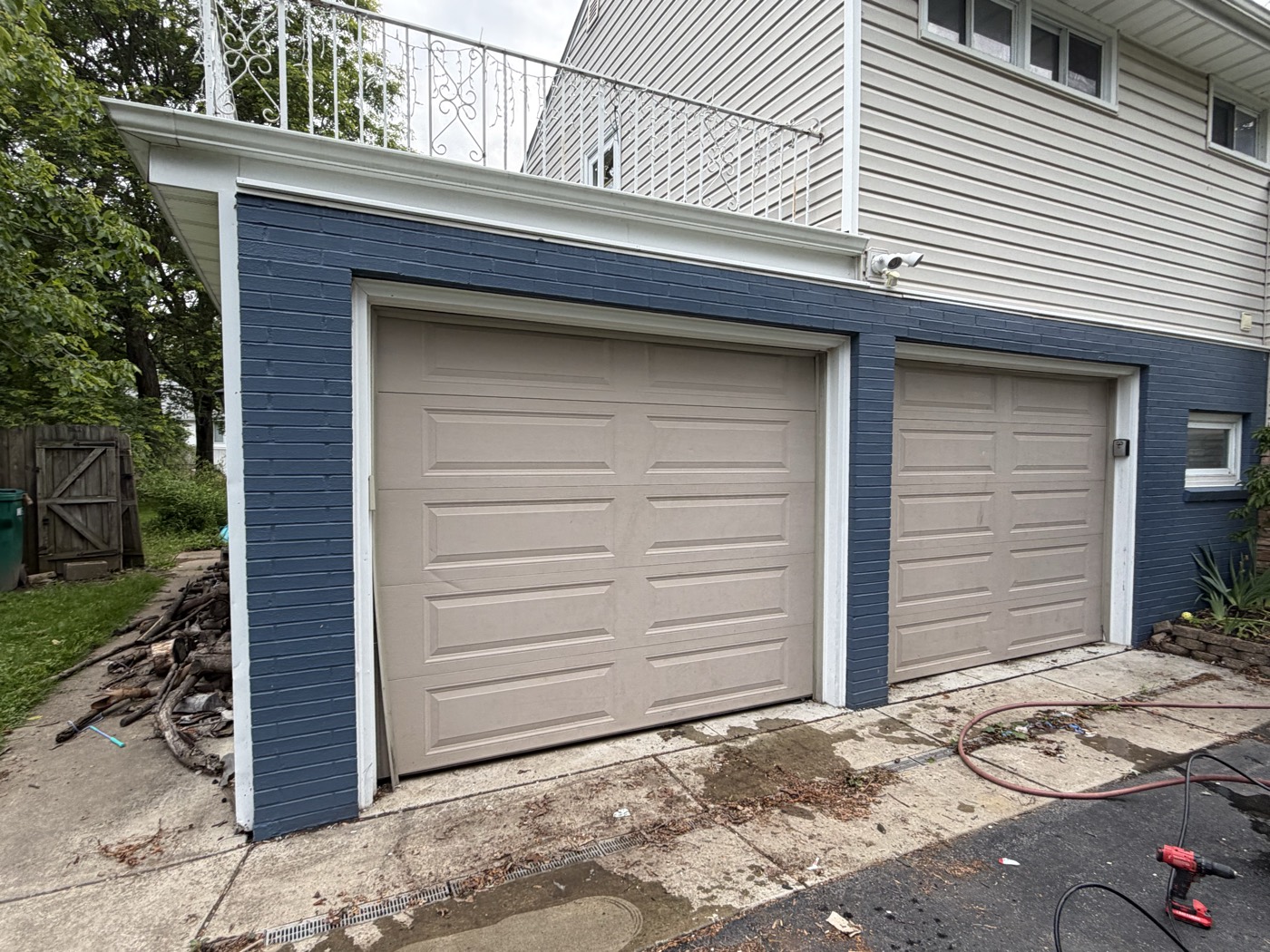 Garage driveway before pressure washing, covered in leaves, dirt, and debris